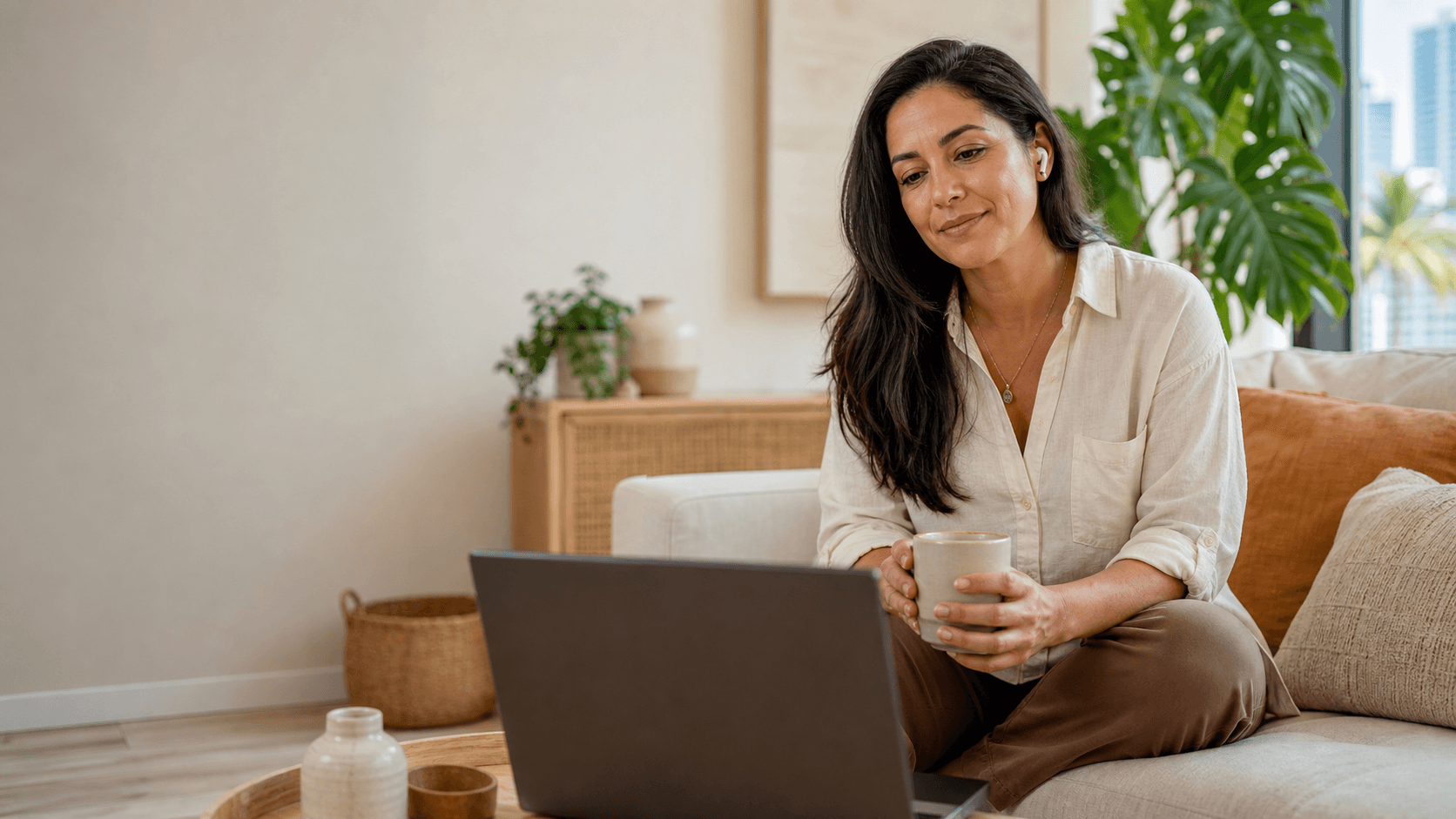 Calm blue-toned teletherapy scene with a therapist on laptop screen beside a notebook and soft window light.